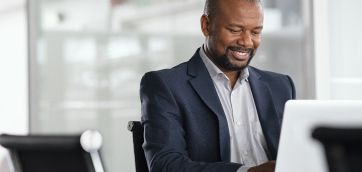 Smiling man at a computer - Healthstream