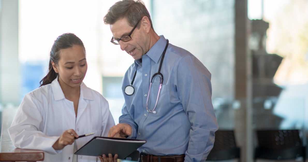 Two medical professionals looking at notebook - HealthStream Retention Analytics
