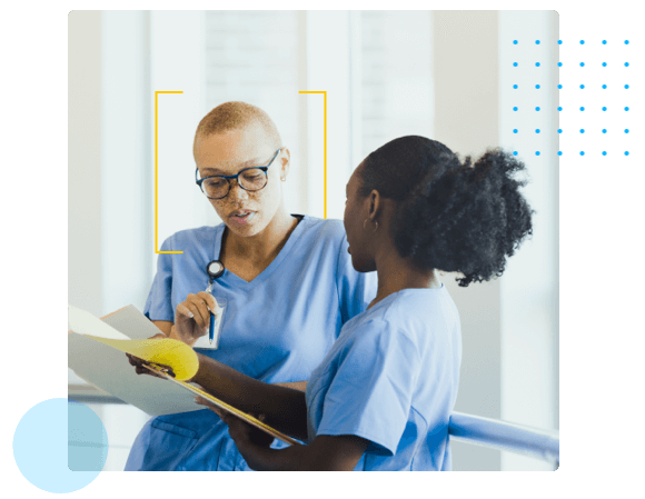 Leadership Pathways Two Nurses in Blue Scrubs Speaking in a Hallway