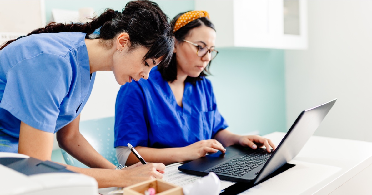 Medical professionals working at a desk - Policy Manager HealthStream